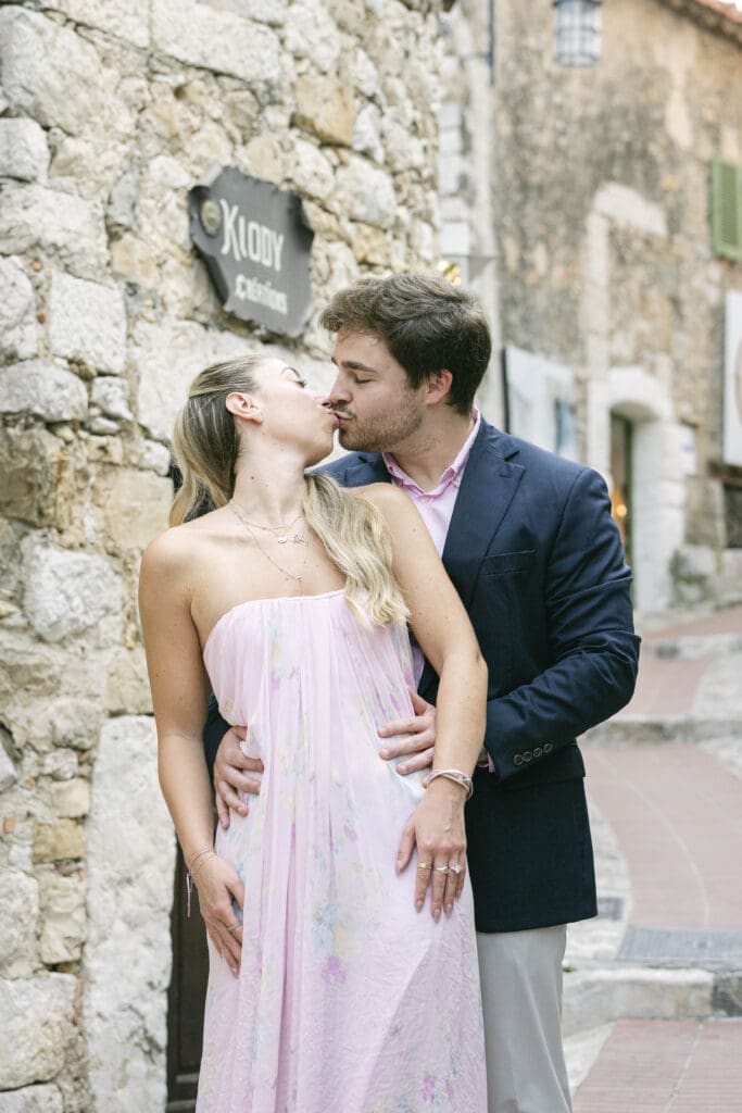 Couple photographié après sa demande en mariage avec vue sur le village d'Èze et la mer Méditerranée