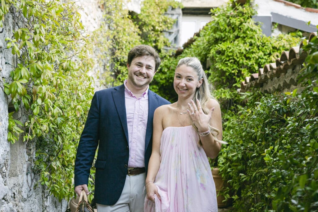 Couple photographié après sa demande en mariage avec vue sur le village d'Èze et la mer Méditerranée