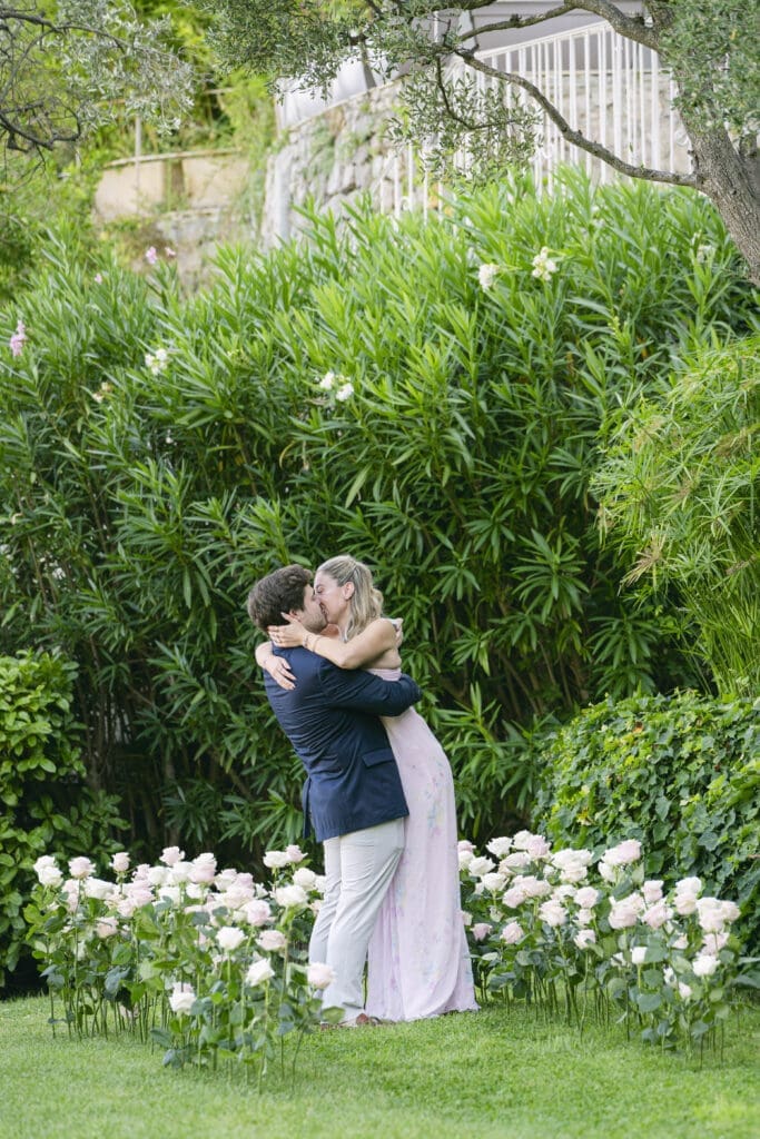 Demande en mariage genou à terre entouré de roses aux Jardins de la Chèvre d'Or
