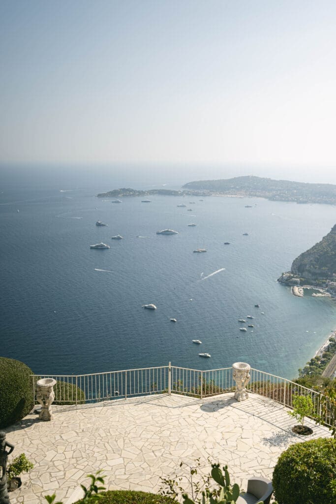 Couple photographié après sa demande en mariage avec vue sur le village d'Èze et la mer Méditerranée