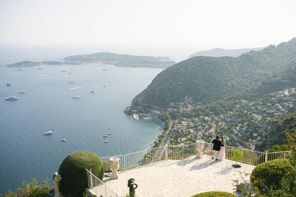 Couple photographié après sa demande en mariage avec vue sur le village d'Èze et la mer Méditerranée