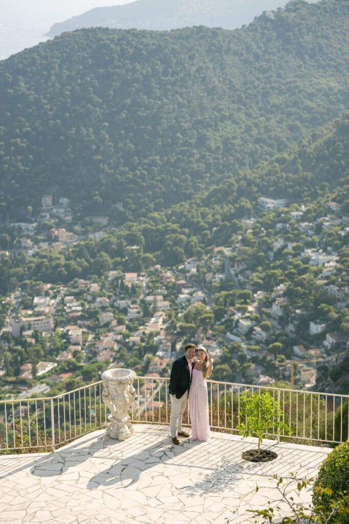 Couple photographié après sa demande en mariage avec vue sur le village d'Èze et la mer Méditerranée